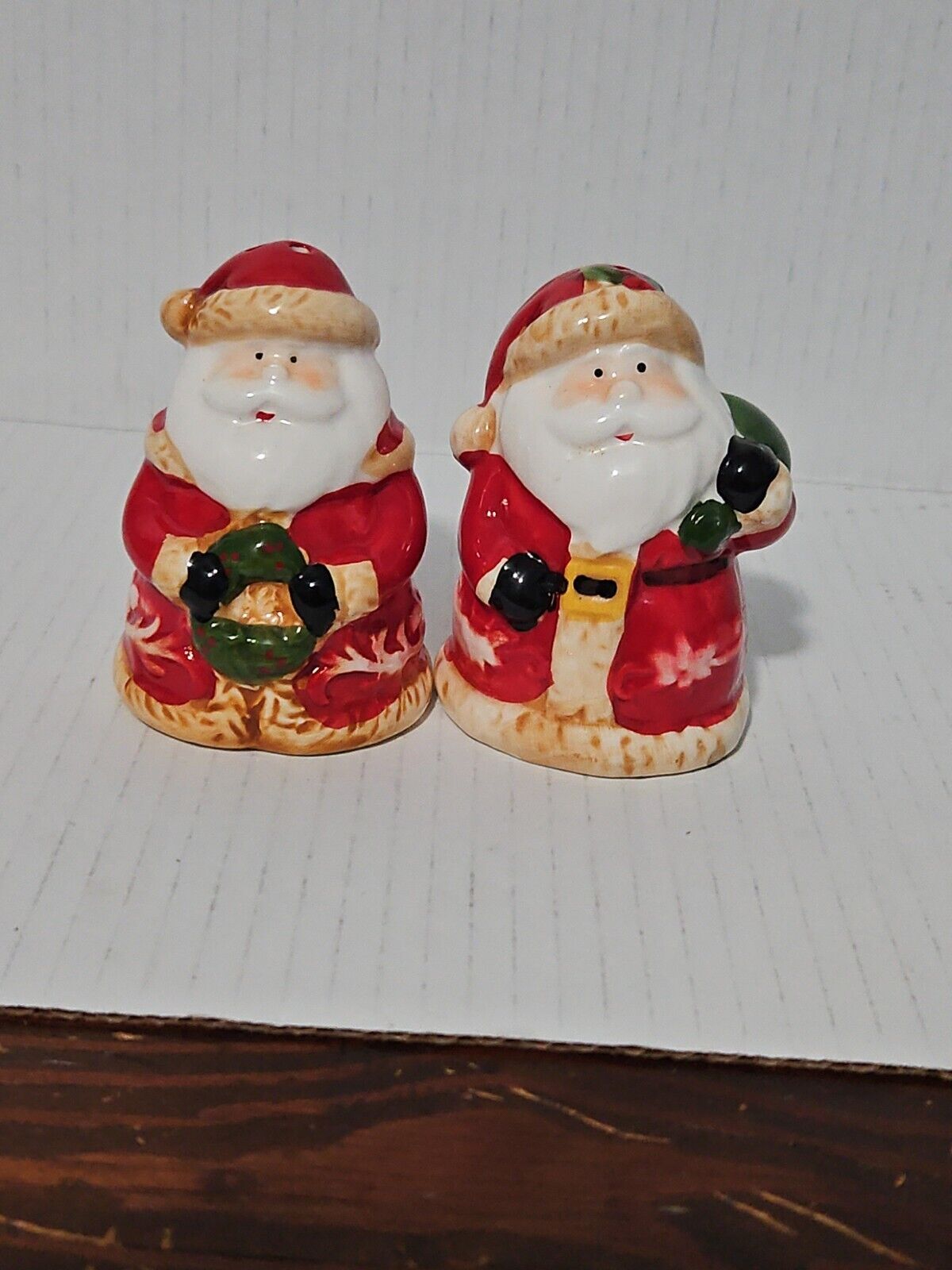 Santa Claus Salt And Pepper Shakers. Santas Holding A Christmas Wreath