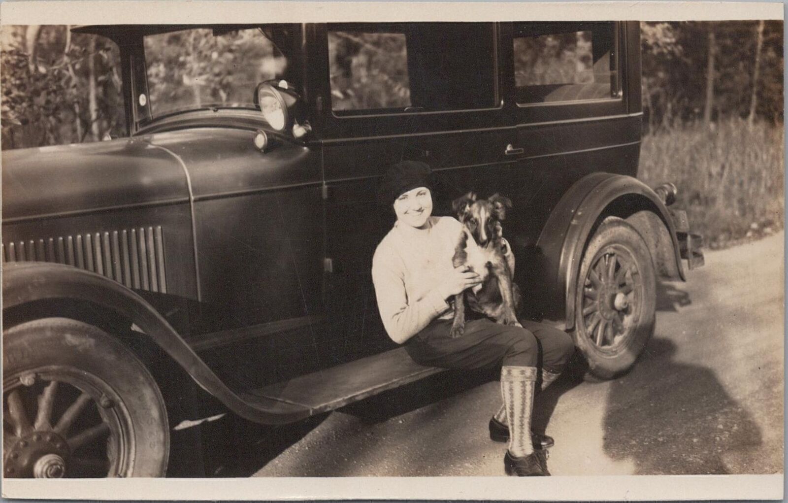 RPPC postcard Woman Posing With Puppy Dog On Antique Car 1931