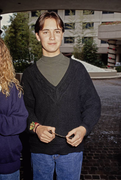 Wil Wheaton wearing a green crew-neck top beneath a black v-neck s- Old Photo