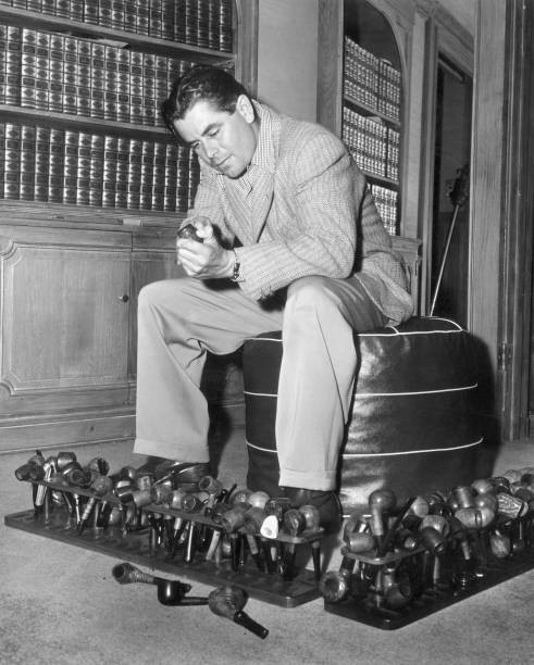 Canadian actor Glenn Ford sitting a study cleaning a pipe with rest- Old Photo Canadian actor Glenn Ford sitting a study cleaning a pipe with rest- Old Photo