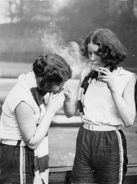Two members of the Civil Service Ladies Rowing Club smoking a ciga- Old Photo