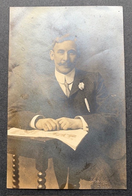 VTG EARLY 1900\'S RPPC WELL GROOMED YOUNG MAN SITTING AT TABLE SUIT TIE MUSTACHE