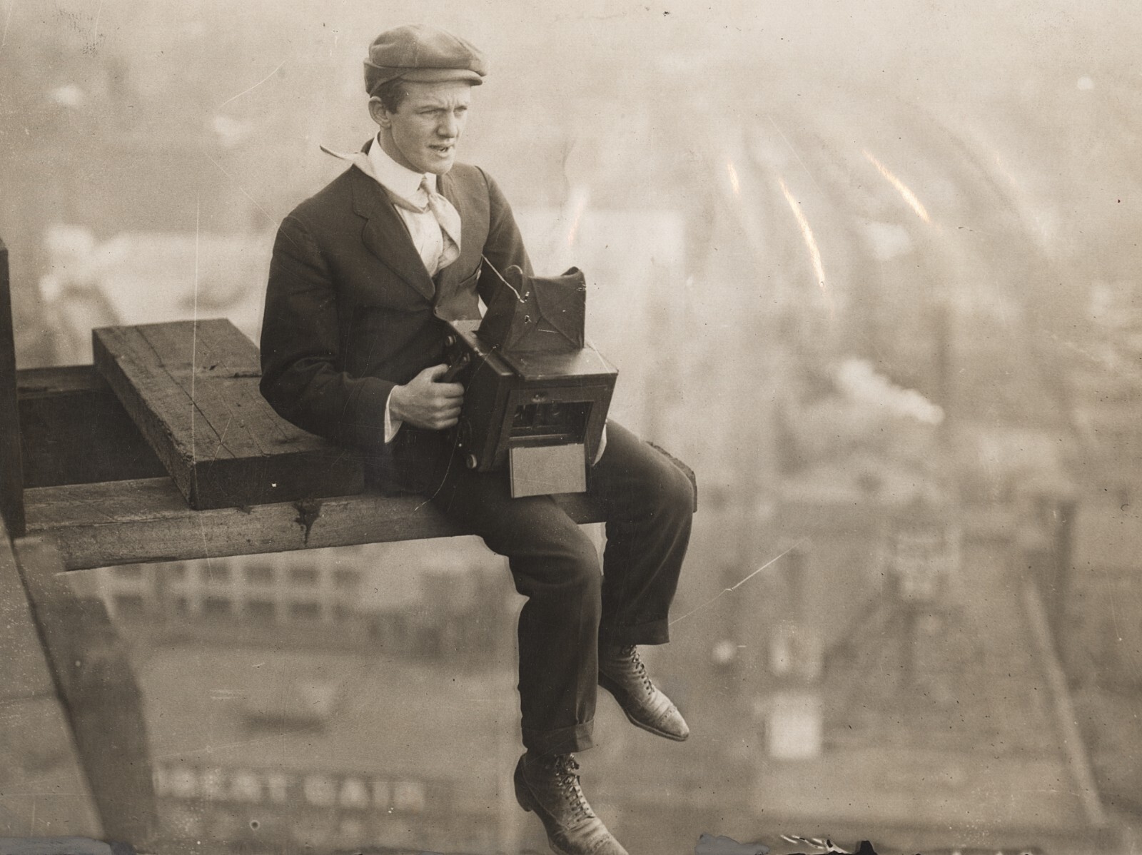c. 1910's News Photographer Sitting on Girder of Sky Scraper Construction Photo