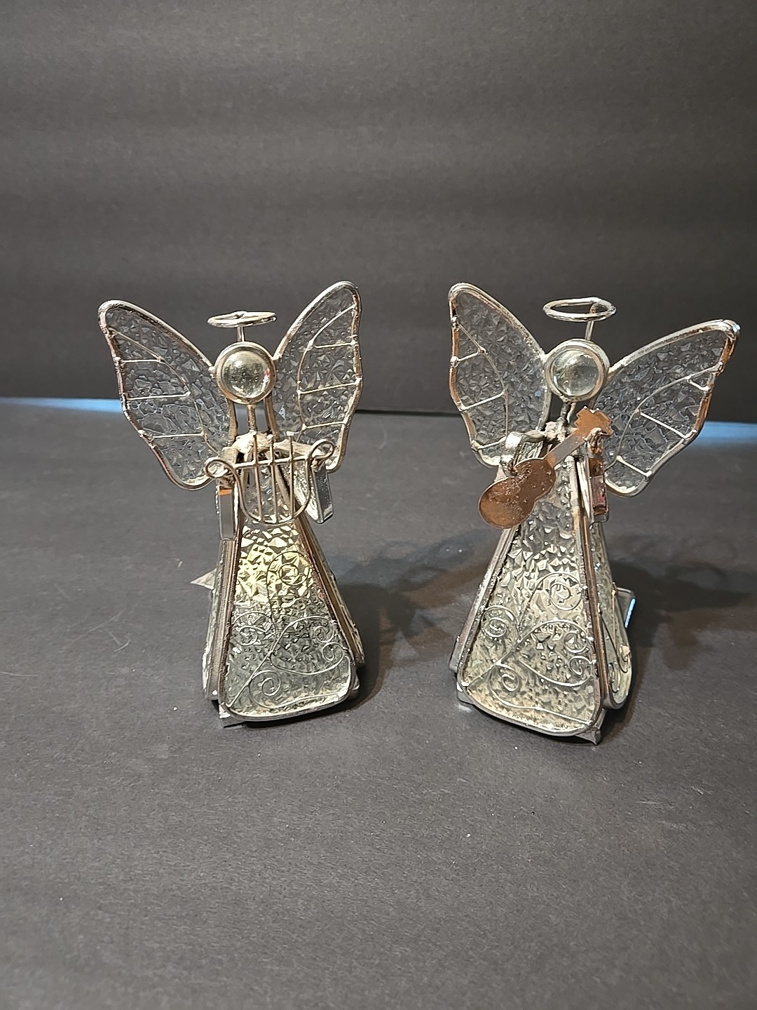 Two stained glass and metal angel candle holder figurines.
