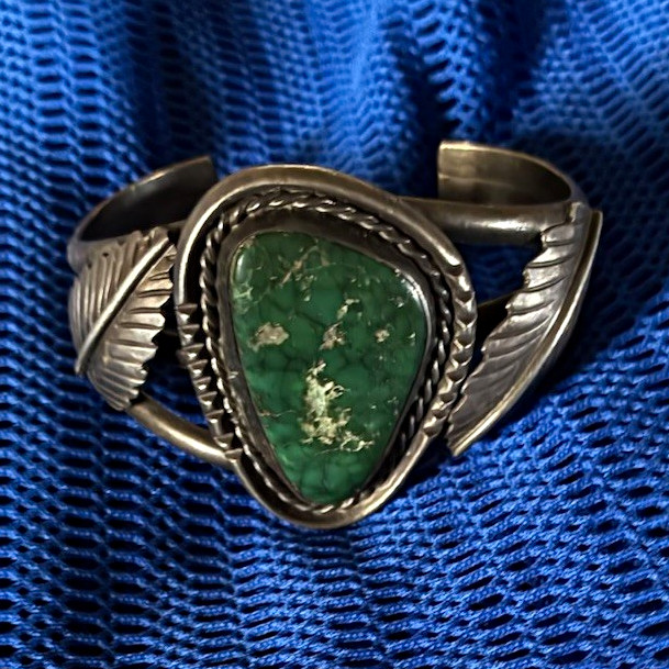 vintage Navajo sterling silver cuff bracelet featuring a striking green turquois