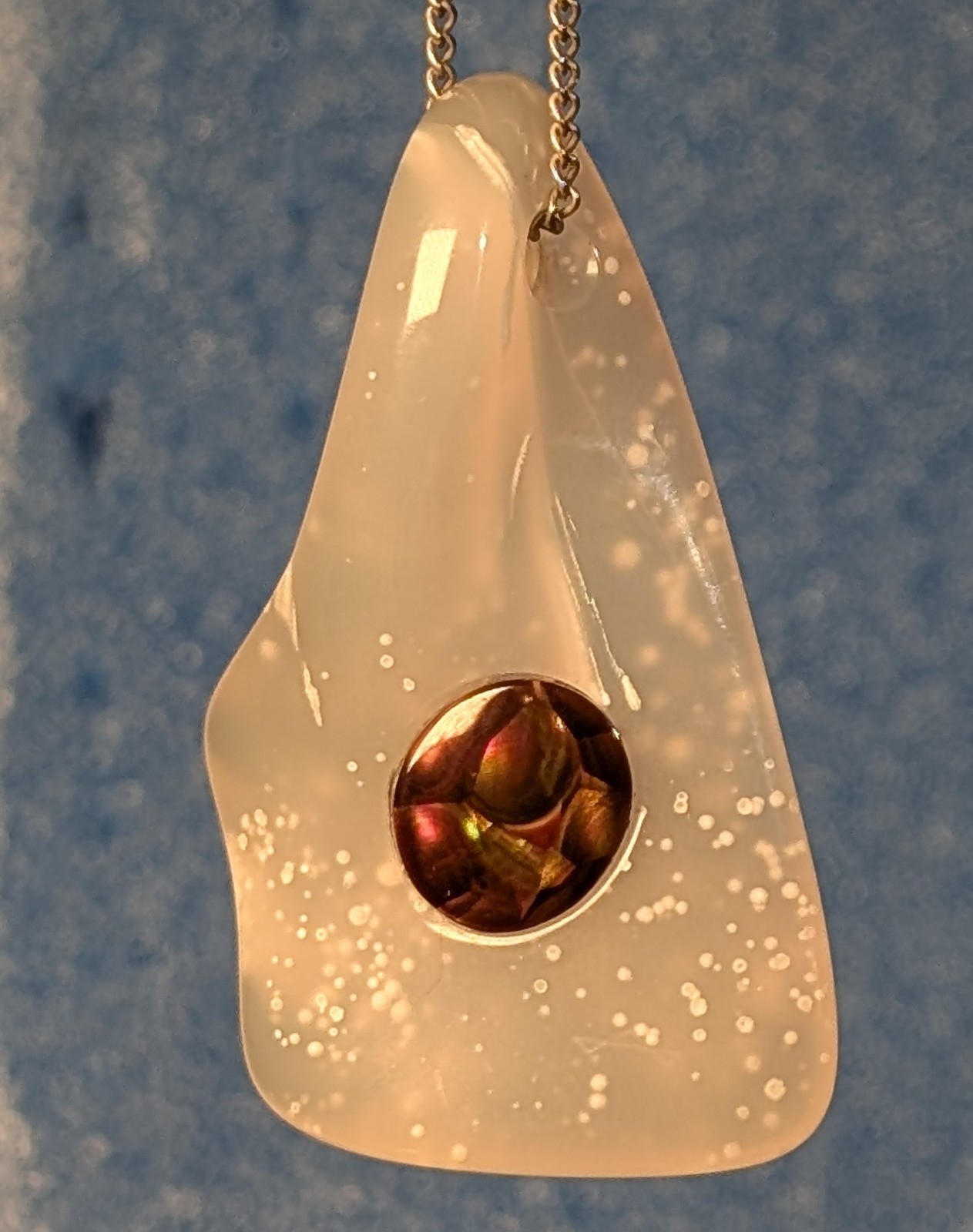 Carved pendant; Polka dot agate inlaid with fire agate cabochon