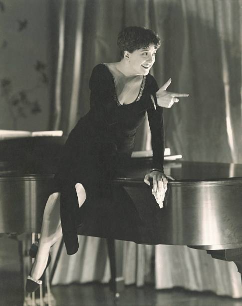 Singer Helen Morgan in a black dress with deep plunge sitting on 1930s Old Photo