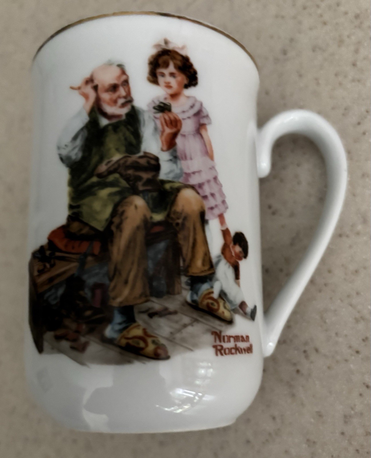 NORMAN ROCKWELL “THE COBBLER “ Mug/Cup-Cobbler Repairs Girls Doll Shoe-1982. NORMAN ROCKWELL “THE COBBLER “ Mug/Cup-Cobbler Repairs Girls Doll Shoe-1982.