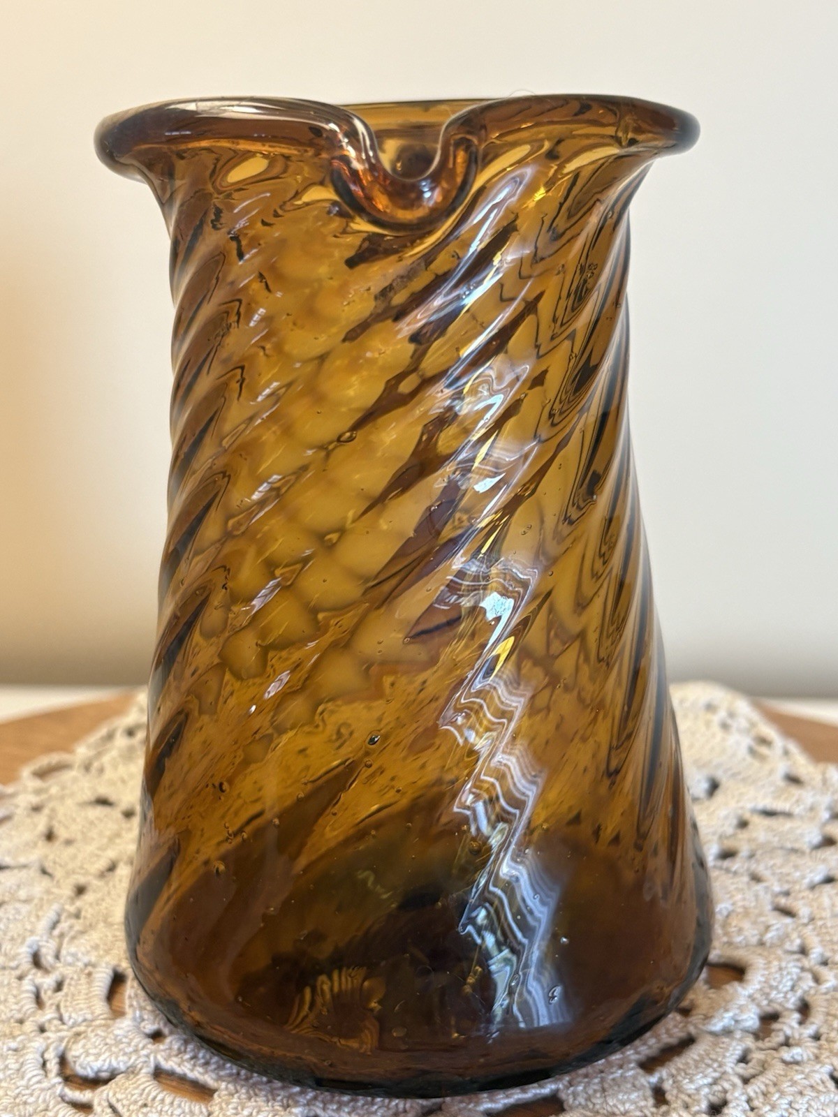 VINTAGE HAND BLOWN AMBER GLASS PITCHER WITH TWISTED SWIRL. Almost 5” Tall.