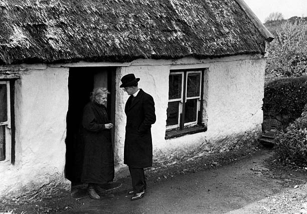 Parish priest Father Bolton talks to an elderly lady Mrs Hourigan - Old Photo