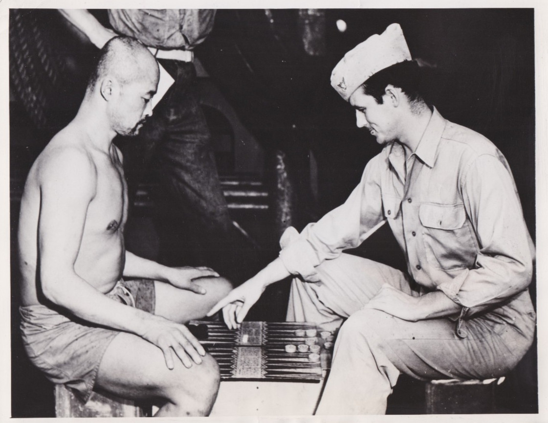 1945 Press Photo WW2 Prisoner from Battle of Peleliu plays Acey-Deucey with USCG
