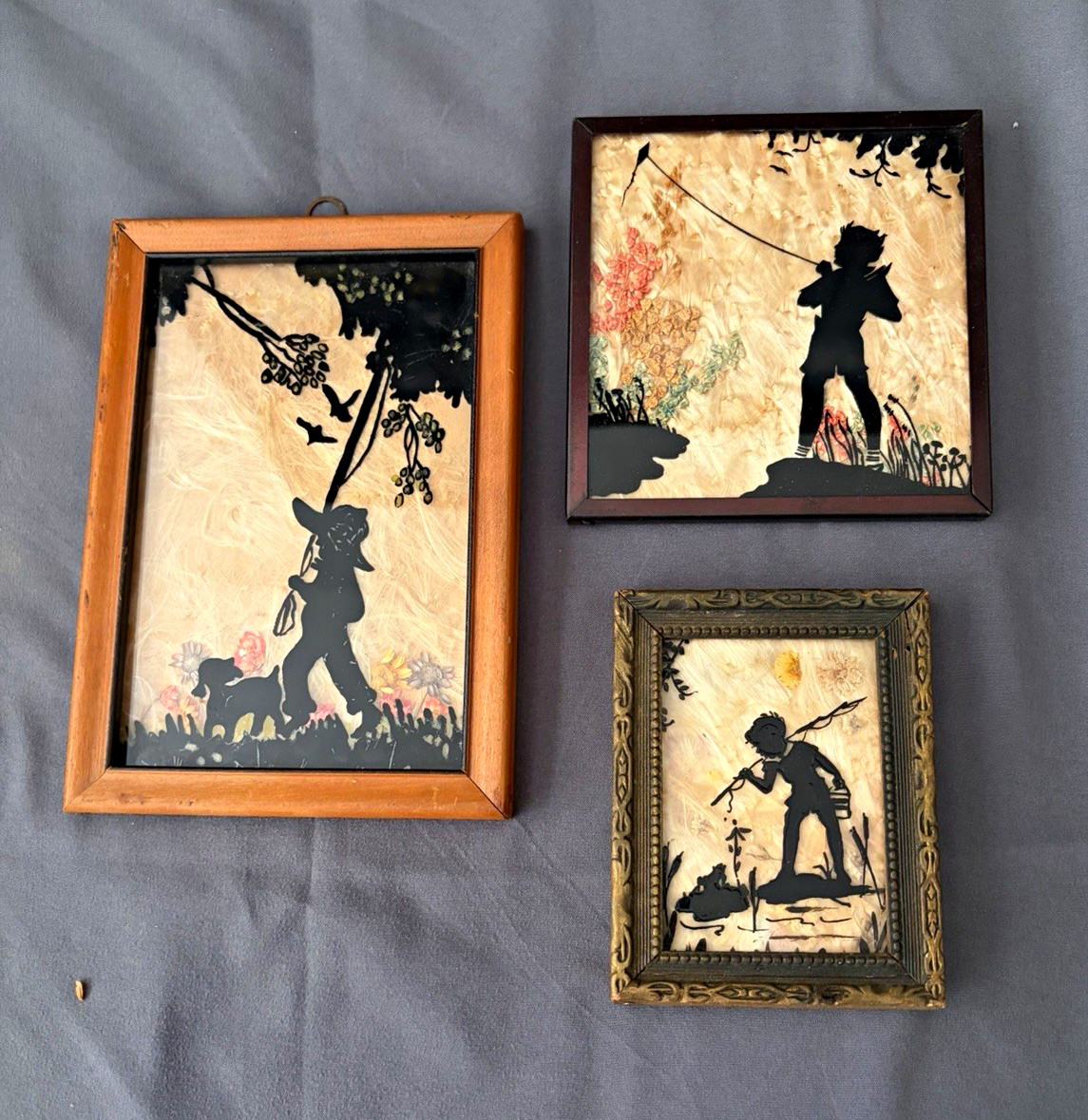 3 silhouettes.  wood framed.  Milkweed/wildflower backdrop. Kids in nature