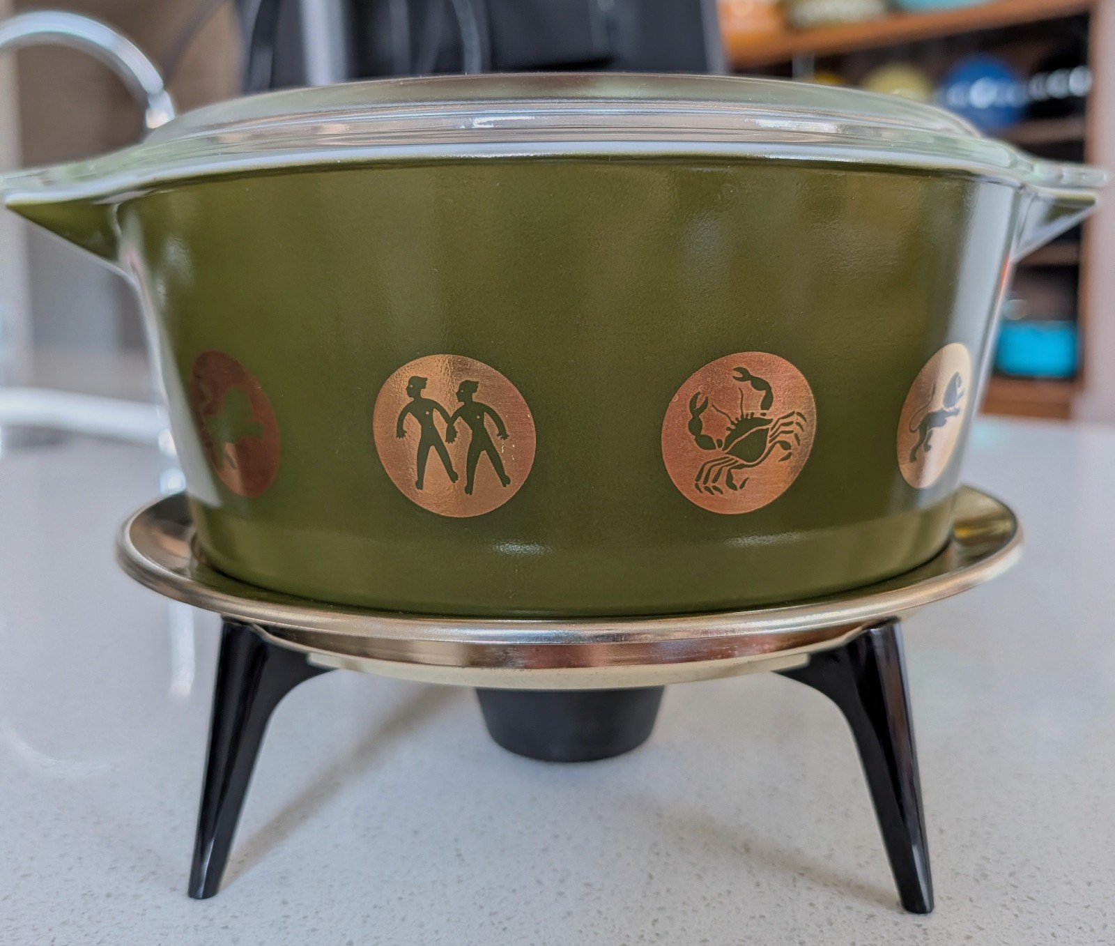 vintage pyrex zodiac 575 with lid, stand, and advertisement insert