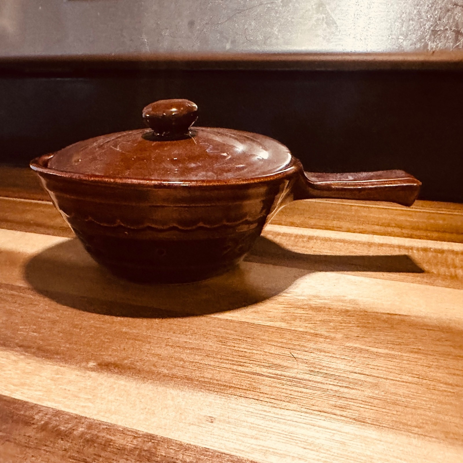 Brown ceramic covered handled bowl Brown ceramic covered handled bowl