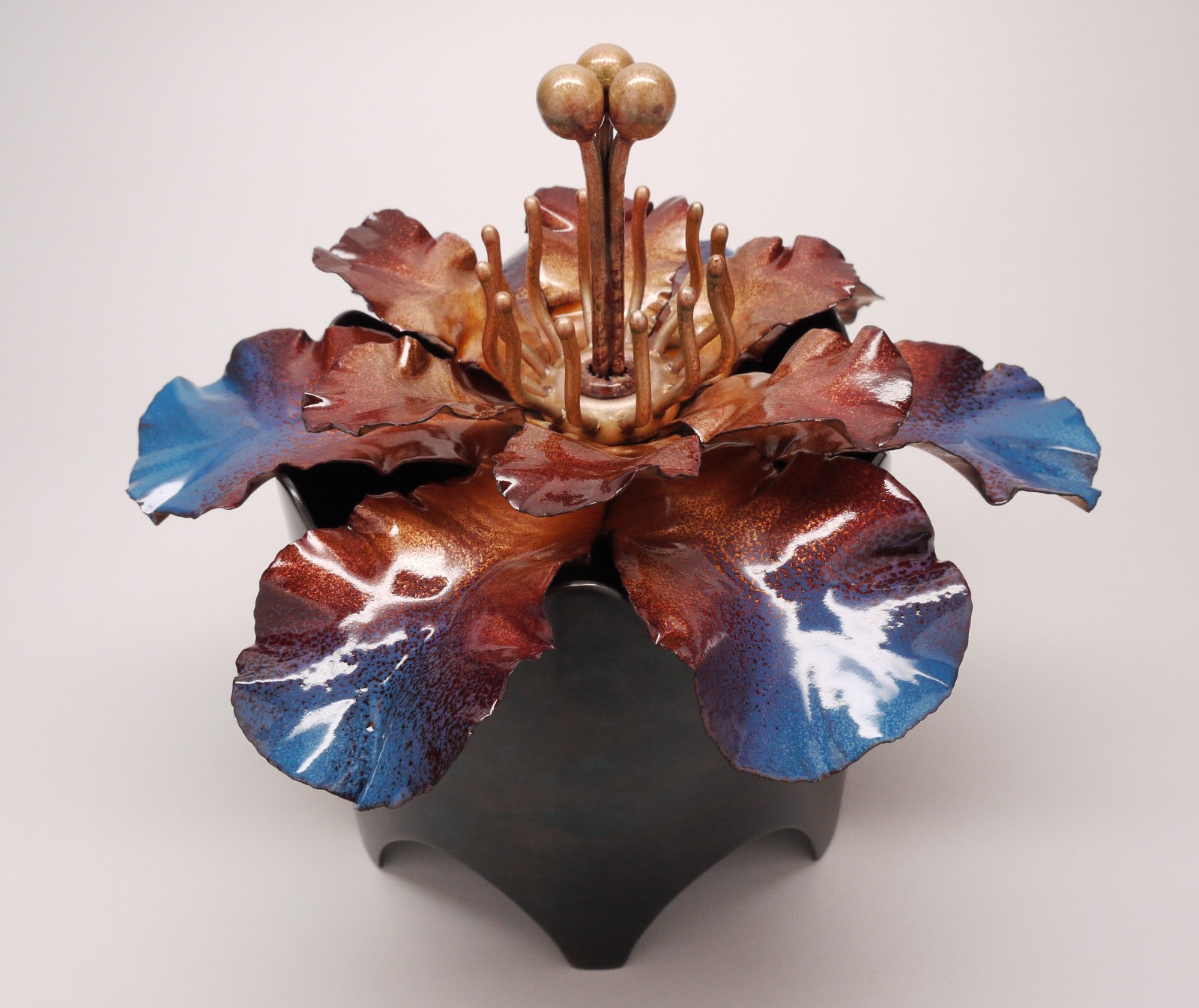 Handcrafted vessel, copper and glass enamel flower lid with a steel base.