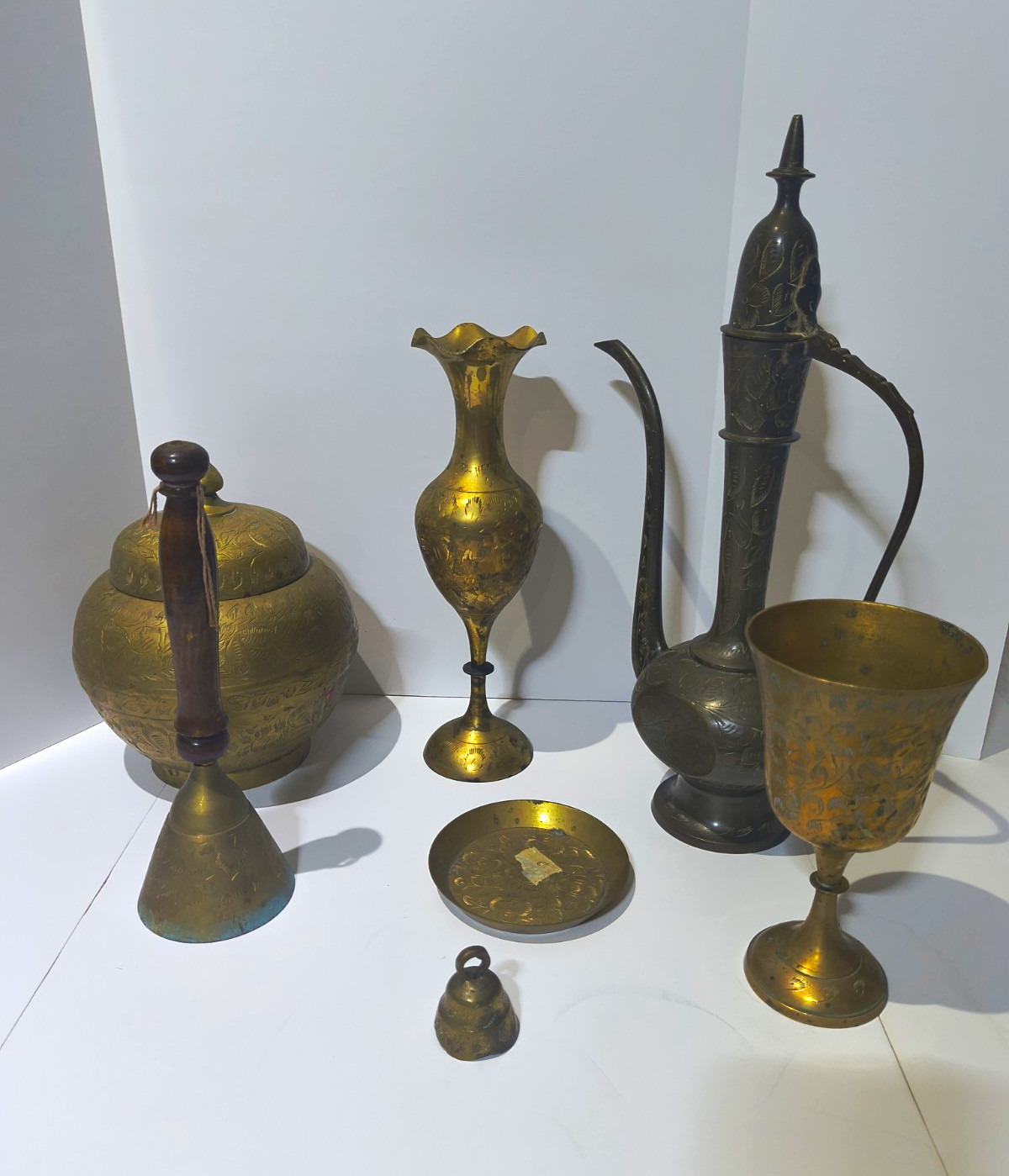 Vintage Indian Etched Brass Lot - 7 Pcs Ewer Pitcher, Chalice, Vase, Bells & Pot Vintage Indian Etched Brass Lot - 7 Pcs Ewer Pitcher, Chalice, Vase, Bells & Pot