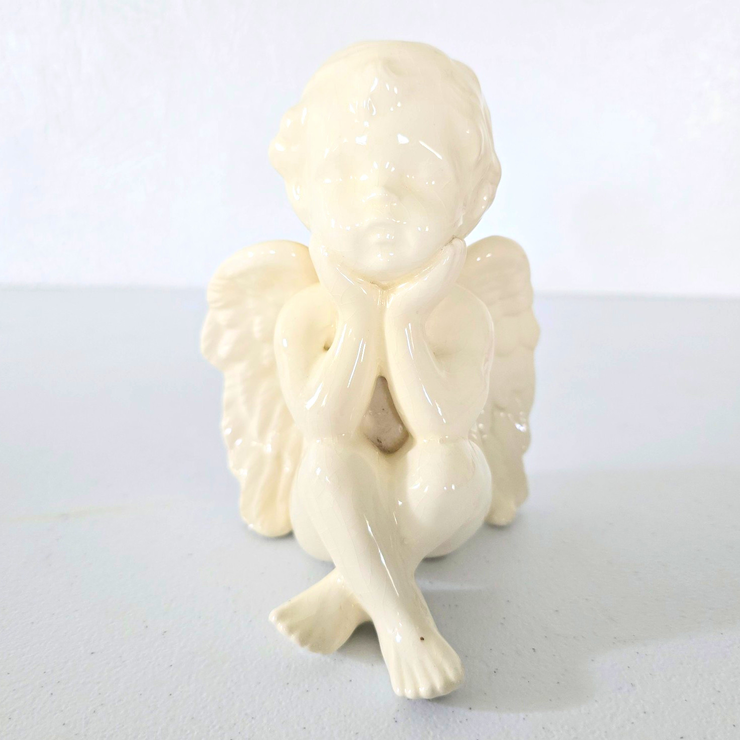 Vintage glossy white ceramic cherub figurine with detailed wings, 6\