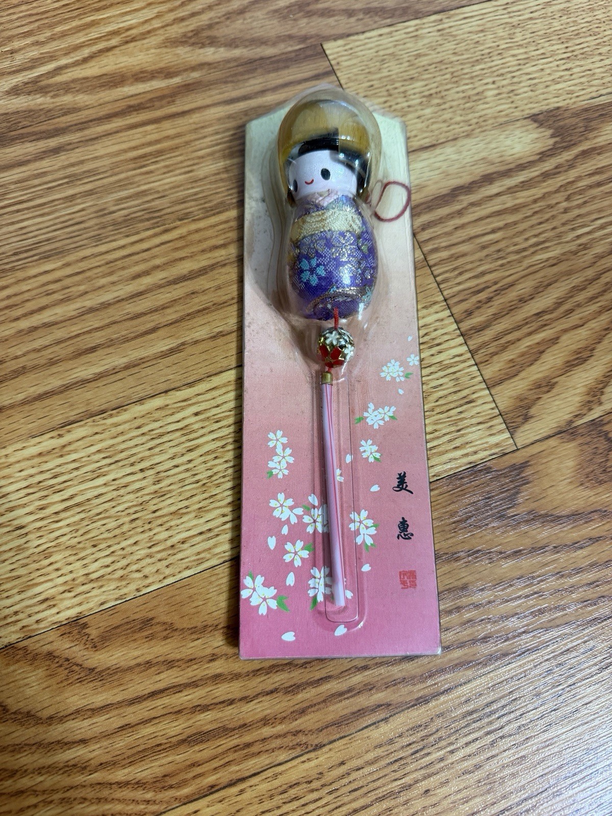 Japanese kokeshi doll souvenir featuring a floral patterned kimono in Package