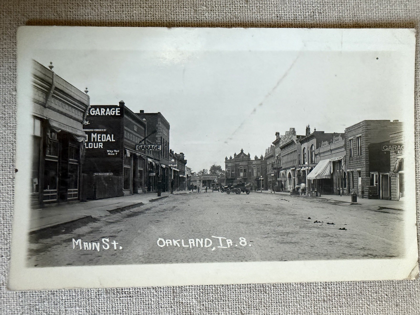 1917 RPPC Oakland Iowa Main Street Downtown Garages Cars Storefronts IA Postcard