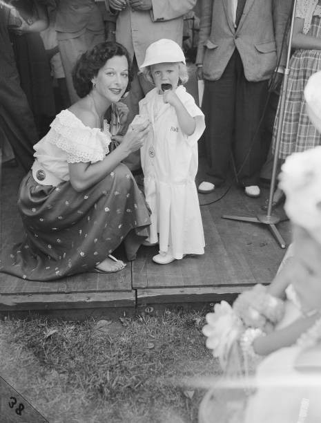 Austrian-born American actress Hedy Lamarr kneels down attends to - Old Photo