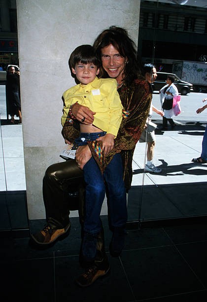 Steven Tyler of Aerosmith shown with his son arrives here for the - Old Photo