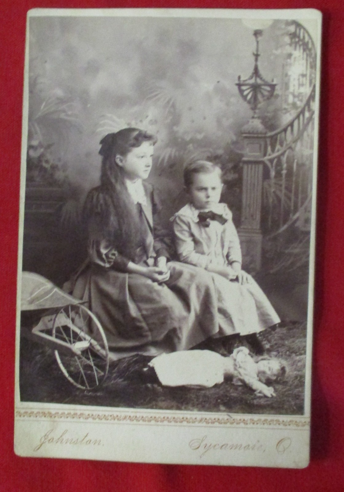 Cabinet Card Photo, Boy and Girl Seated on Cart, Doll on Floor