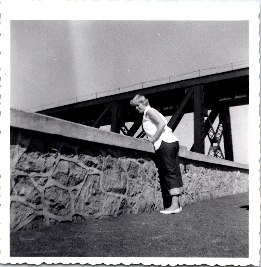 Big Butt Blonde Woman Leaning on Stone Wall Near Bridge 1950s B&W Snapshot Photo
