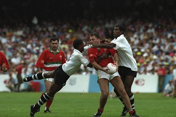Emyr Lewis of Welsh Presidents Seven is tackled by Sakeasi Vonolag- Old Photo