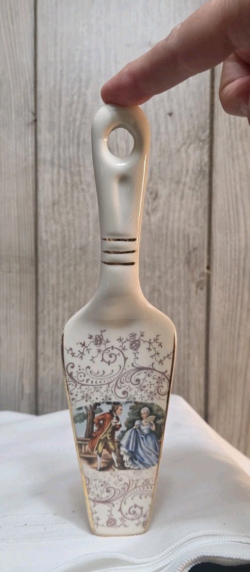 CERAMIC PIE CAKE SERVER: Colonial Man & Woman w/fan, standing, gold swirls, 9
