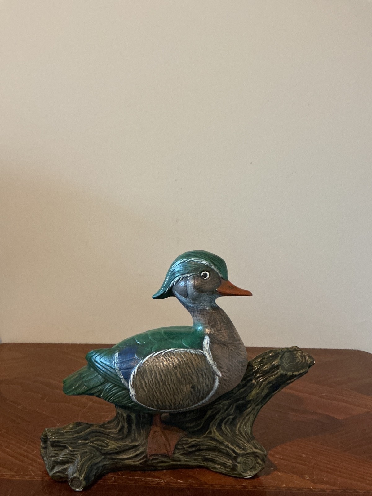 hand-painted ceramic or porcelain wood duck figurine perched on a textured branc