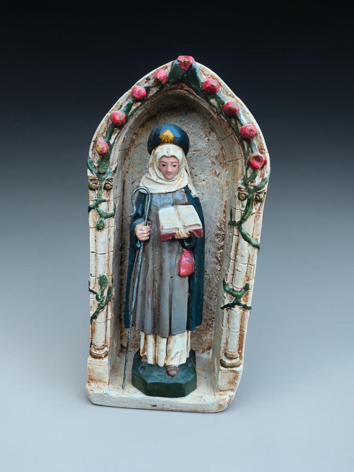 Antique chalk statue Of Saint Bona of Pisa in niche chapel with roses