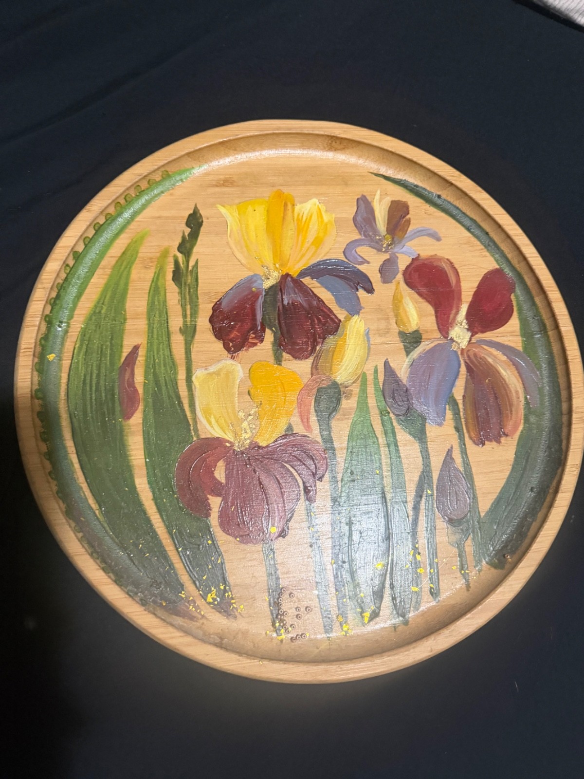 Decorative hand-painted plate featuring iris flowers in shades of yellow, burgun