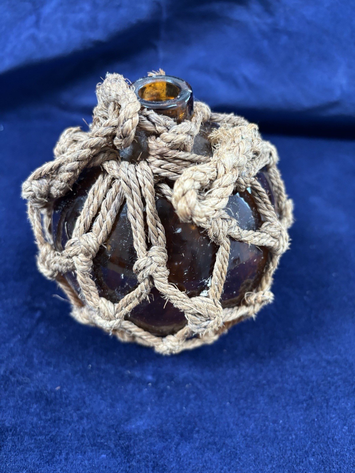Amber glass fishing float — vintage French buoy in rope net