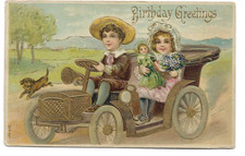 ANTIQUE BIRTHDAY Postcard    BOY IN AUTO, GIRL HOLDING DOLL, PUPPY RUNNING ALONG picture