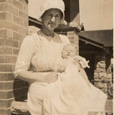 c1910s Mother Holding Sleeping Baby Snapshot Photo Bonnet Apron Brick Porch Vtg picture