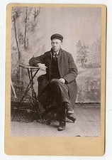 Cabinet Photo - Man Wearing Cap & Long Coat Sitting - Outdoor Backdrop  picture