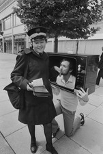 Comedian Kenny Everett kneels to kiss the hand of an amused traffi- Old Photo picture