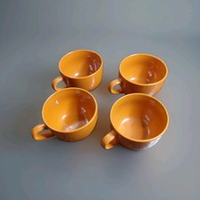 four vibrant orange ceramic jumbo mugs picture