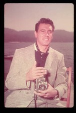 Famous actor Rock Hudson sits along the water holding a twin-lens - Old Photo picture