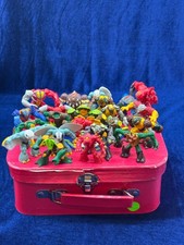 A Collection Of Various Gormiti Figurines Packed In A Pink Suitcase picture