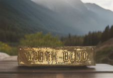 Vintage NORTH BEND E J ARMS Embossed Metal License Plate Topper picture