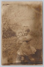 RPPC Happy Little Girl with Big Dollies Blurry Real Photo Vintage Postcard picture