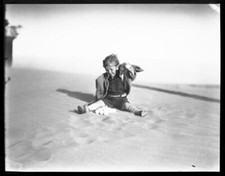 A Young Boy Sitting On A Sandy Ground With A Pile Of What Appear T - Old Photo picture
