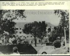 1975 Press Photo Khmer Rouge and Cambodian government troops ride past a School picture