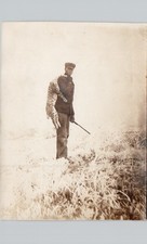 HUNTER CARRIES DEAD BOBCAT c1920 postcard (trimmed) real photo rppc rare picture