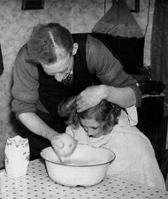 Man washing his daughter's hair face using soapy water in a bowl i- Old Photo picture