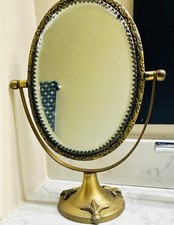 vanity mirror featuring an ornate brass finish and a fleur-de-lis base picture