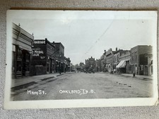1917 RPPC Oakland Iowa Main Street Downtown Garages Cars Storefronts IA Postcard picture