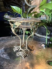 Antique brass pedestal stand featuring a detailed grapevine and leaf motif picture