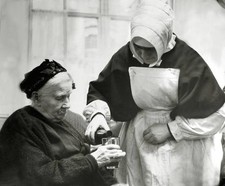 Nun pouring a drink for an elderly woman Historic Old Photo picture